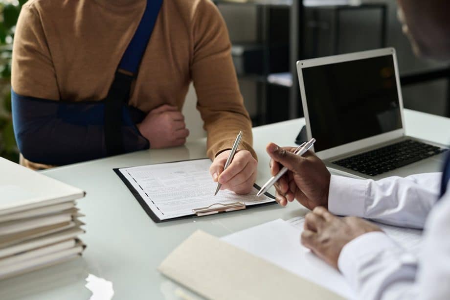 Man in braces signing documents