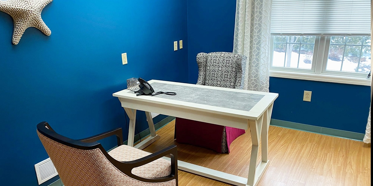 white desk with chairs and white starfish on blue wall